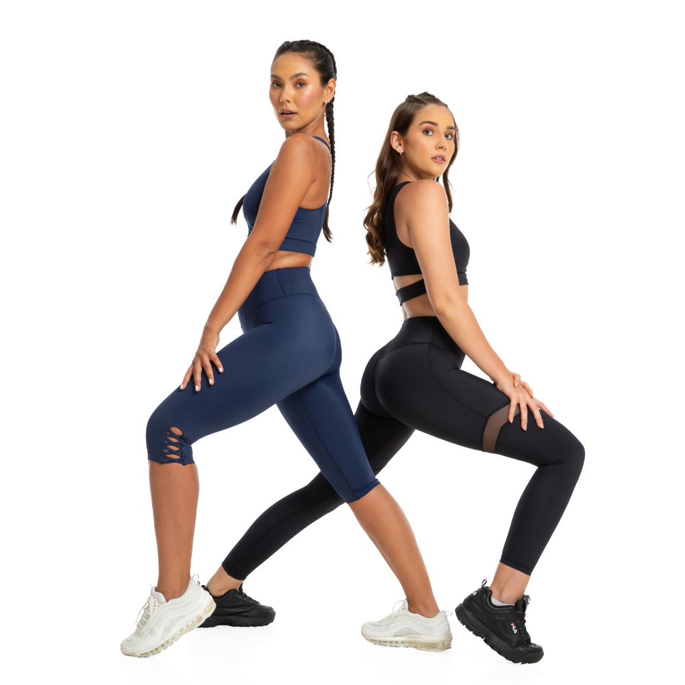  Two girls standing back to back modelling 1Body's Leggings  and crop tops looking at the camera.