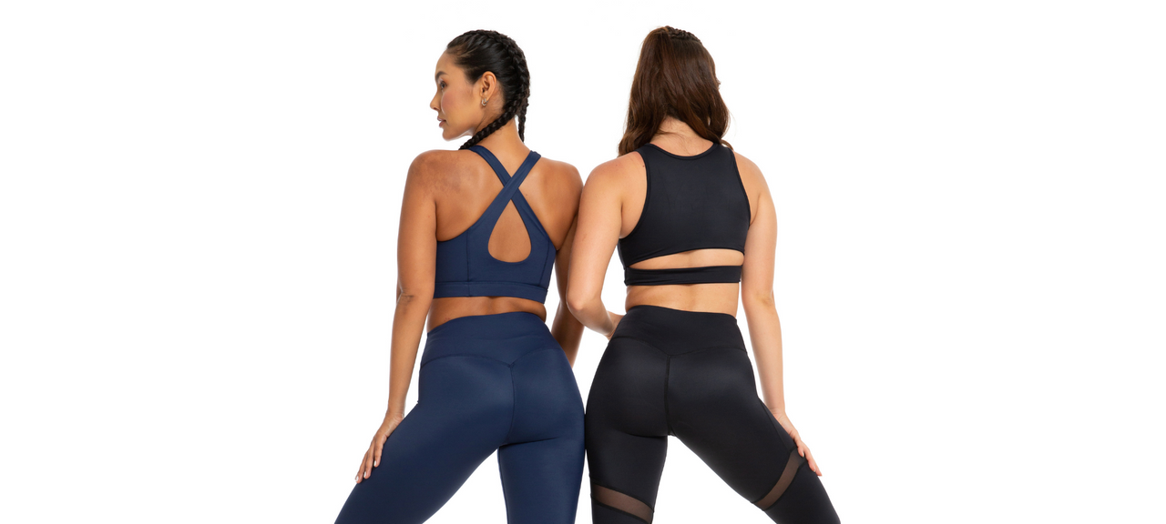  Two girls standing with their backs facing the camera, modelling 1Body leggings and crop tops.